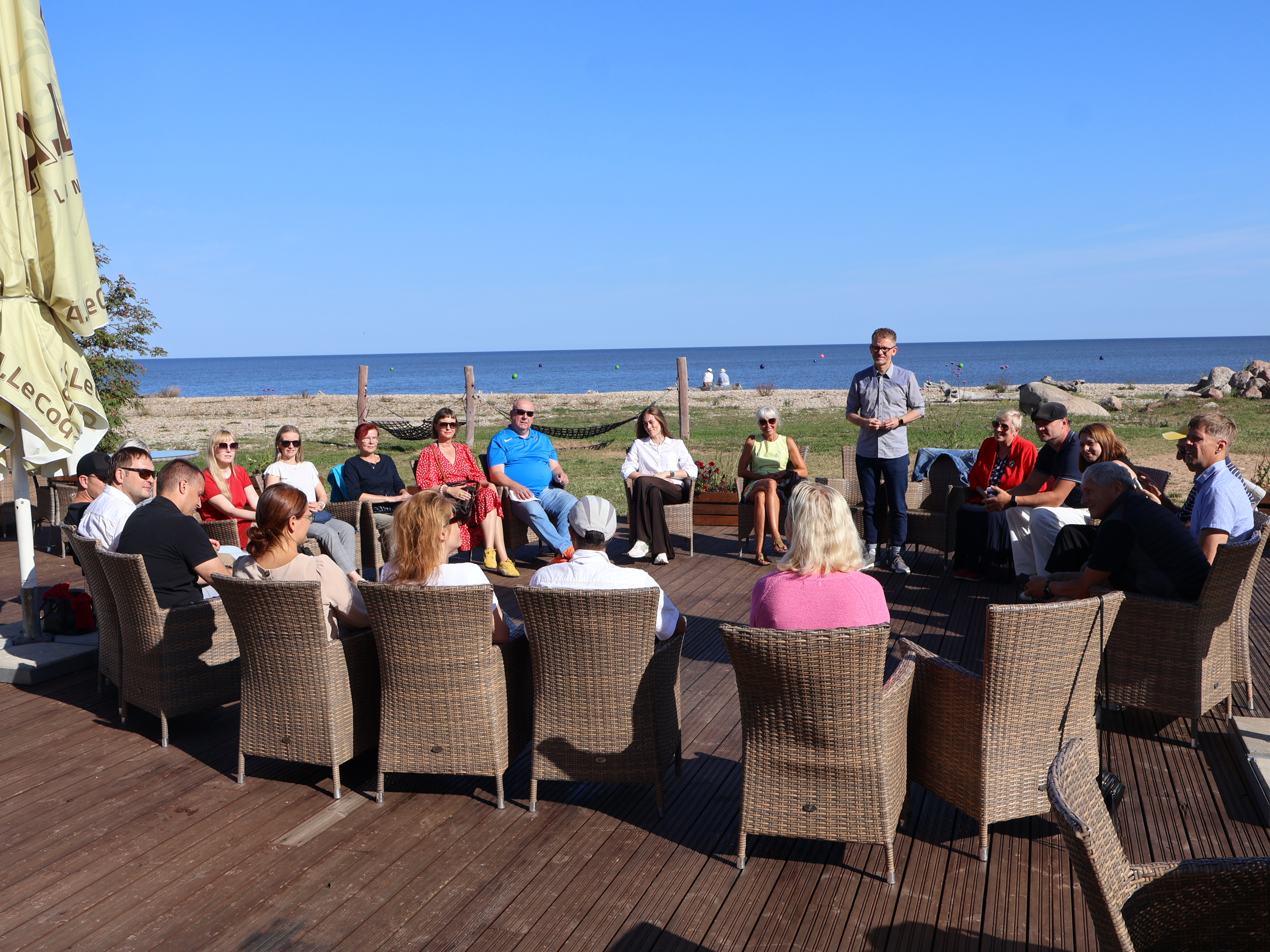 Linnade ja valdade liidu töötajad istumas ringis arutelus, taamal meri